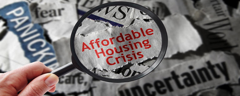 Magnifying glass looking at Affordable Housing Crisis.