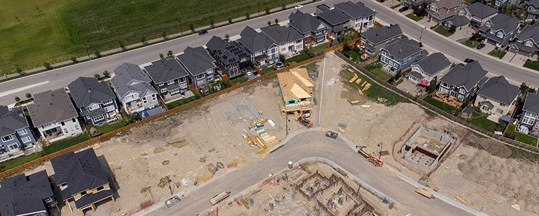 Image of houses next to one another in a new lot where new houses are being built.