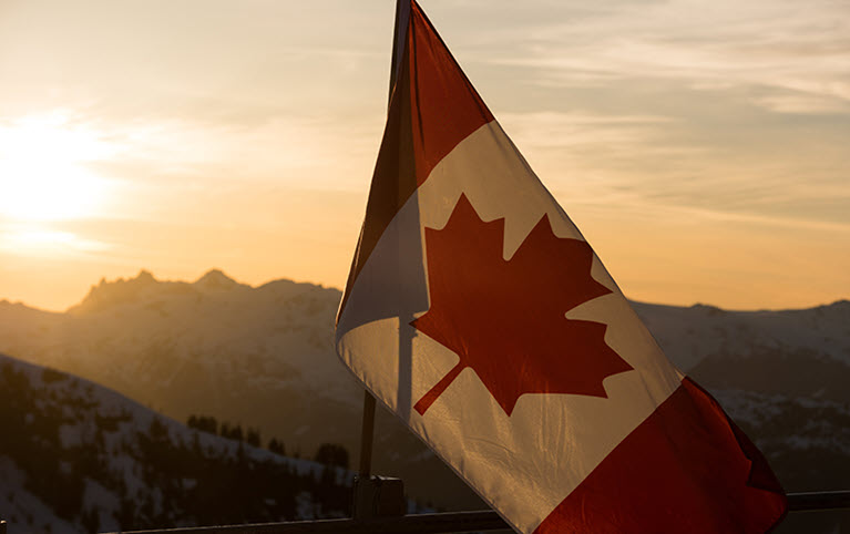 The Canadian flag flowing at sunset representing the federal budget.