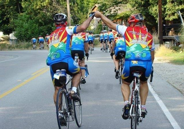 Image of cyclists fist bumping on the road.